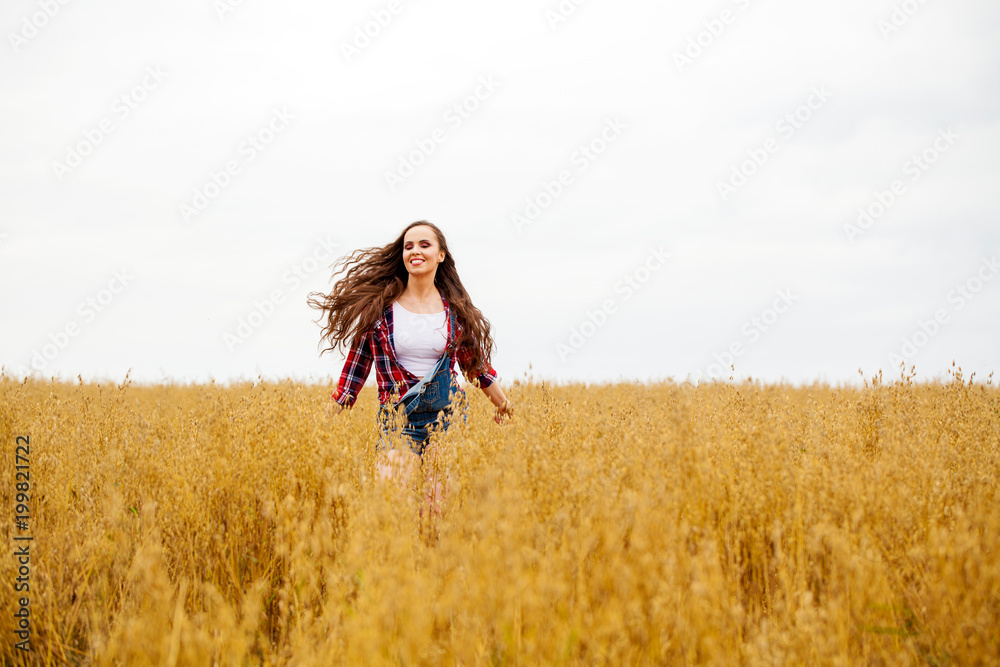 Young beautiful woman walking in a field, summer outdoors Young beautiful woman walking in a field, summer outdoors