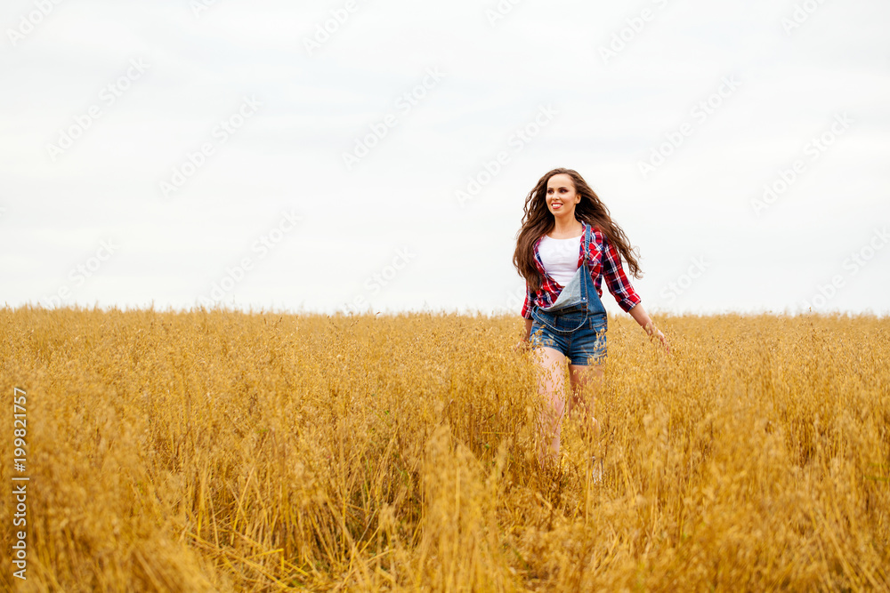 Young beautiful woman walking in a field, summer outdoors Young beautiful woman walking in a field, summer outdoors