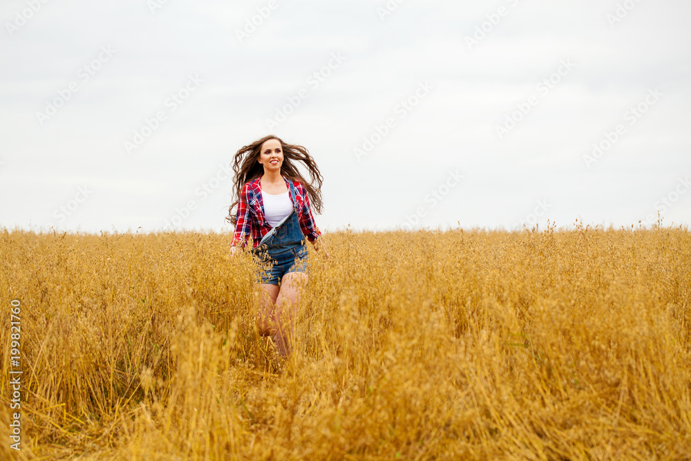 Young beautiful woman walking in a field, summer outdoors Young beautiful woman walking in a field, summer outdoors