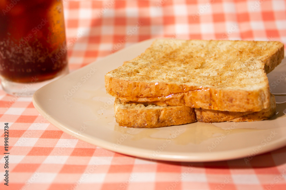 Honey bread with cola on tablecloth background. Closeup side view.