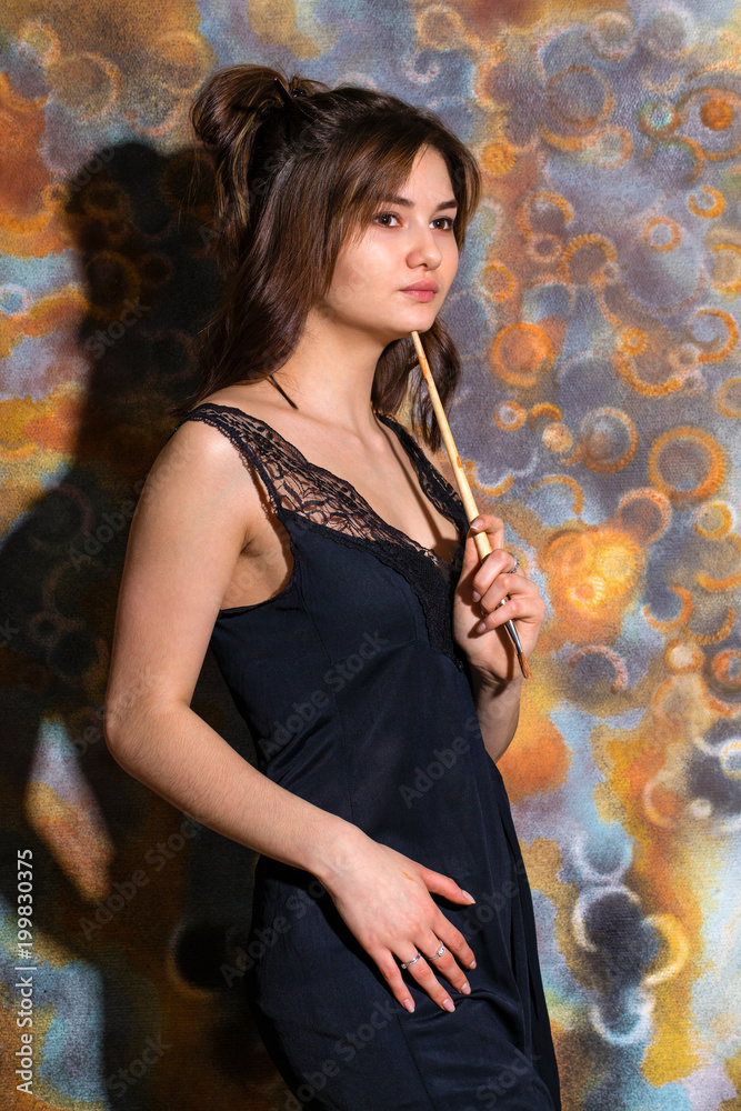 Obraz premium Young beautiful girl posing on the background of painted wall