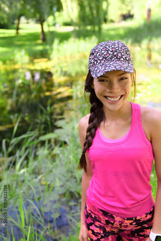Happy smiling young Asian girl in sportswear sports cap and pink