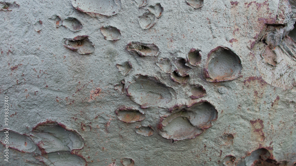 Green metal surface of an old military machine tank is covered by marks ...