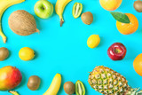 Frame from Different Tropical and Seasonal Summer Fruits. Pineapple Mango Coconut Citrus Oranges Lemons Apples Kiwi Bananas Scattered on Light Blue Background.Healthy Lifestyle Vitamins. Flat Lay