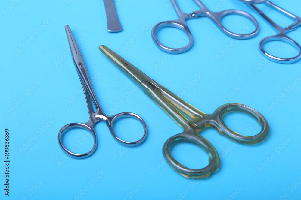 surgical instruments and tools including scalpels, forceps and tweezers arranged on a table for a surgery. surgical instruments and tools including scalpels, forceps and tweezers arranged on a table for a surgery.
