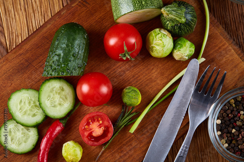 Fresh vegetable salad and ripe veggies on cutting board over wooden background  close up  selective focus