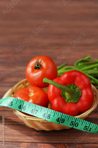 vegetables in a basket on a wooden brown background  tomatoes and red pepper