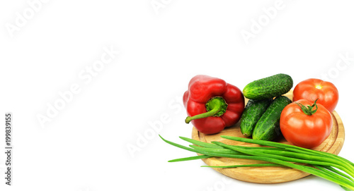 board on a wooden board vegetables with green onions tomatoes red paprika peppers green cucumbers