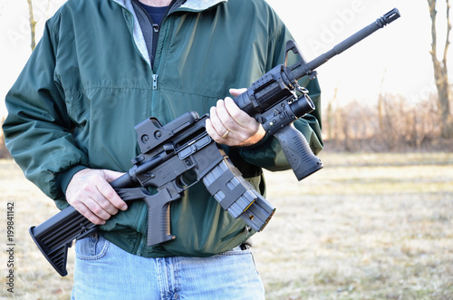 AR-15, M-4 style rifle being held.