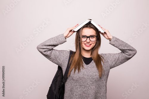 Woman student, holding book on head. Isolated on white background