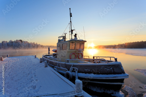 Winter sunset from the river Kymi with old ship in harbor
