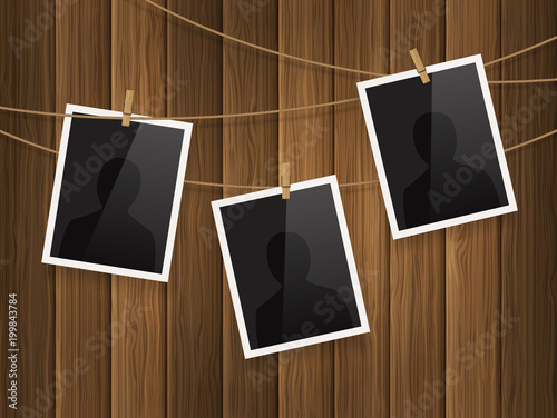 Photo frames fixed on the rope with clothespins on wood background. Vector.