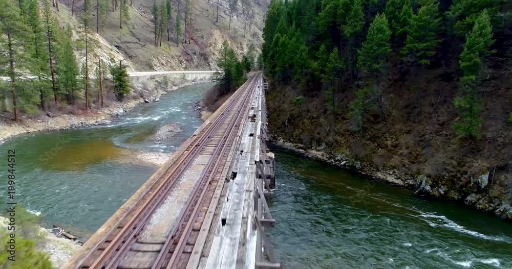 Railroad bridge leading into a forest along a river in Idaho Railroad bridge leading into a forest along a river in Idaho