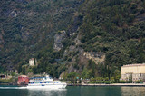 Tourist boat floating on lake Garda, Italy, green mountain on background