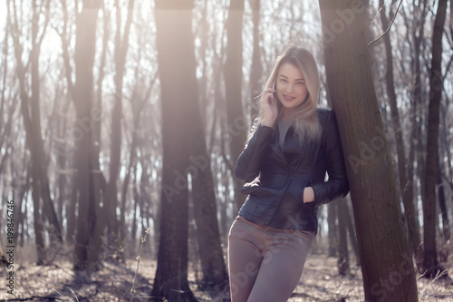 Happy beautiful woman speaking on a cellphone in the park. Autumn time. © Сергей Завальный