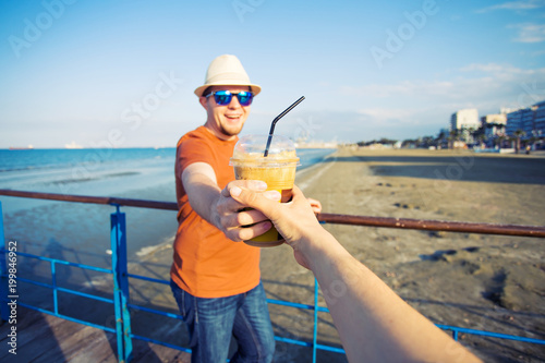Man's and woman's hands close up holding frappe coffee cup photo
