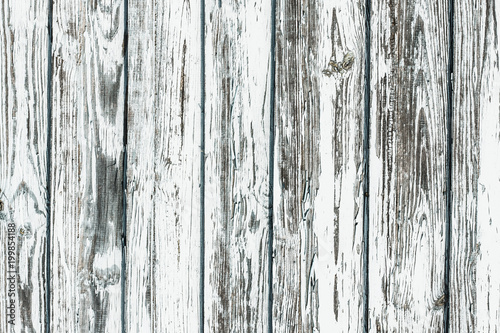 White wooden desk. Peeling paint grunge weathered wall background.