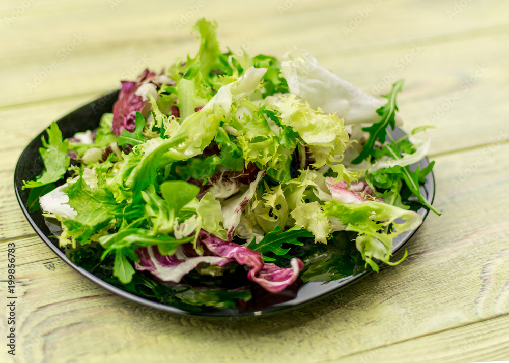 Vegetarian salad of fresh vegetables on a plate on a wooden background. Vegetarian salad of fresh vegetables on a plate on a wooden background.