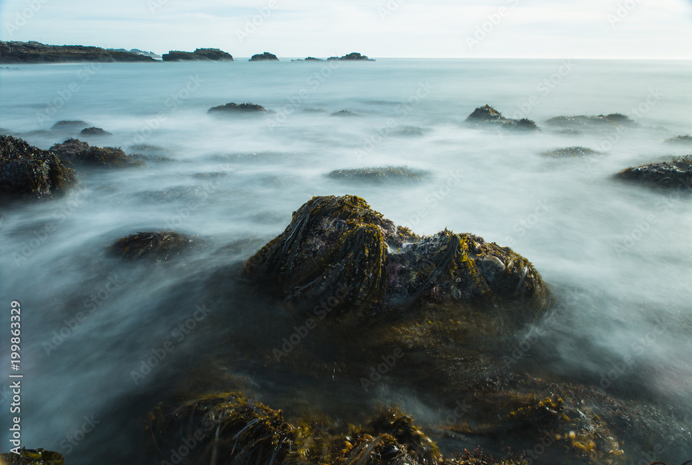 Obraz premium Long exposure photo of the waves and rocks of the tidepools along the California coastline