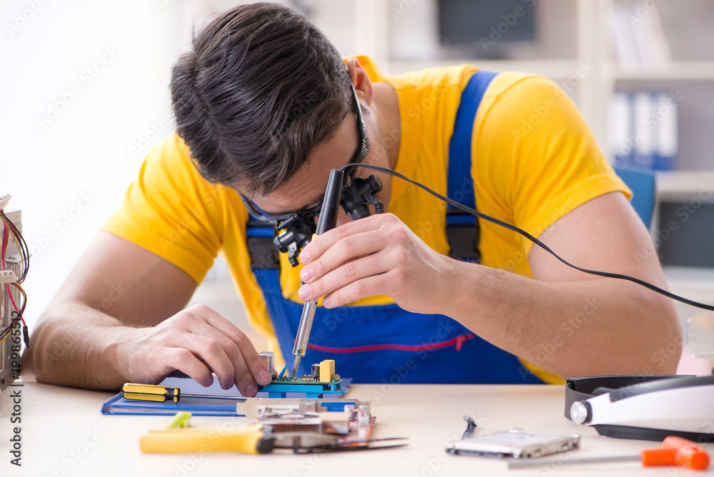 Computer repair technician repairing hardware Computer repair technician repairing hardware