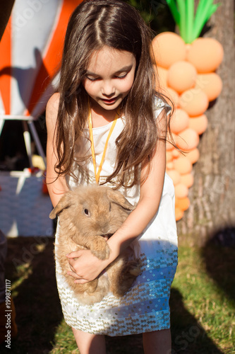 A beautiful girl is holding a rabbit.