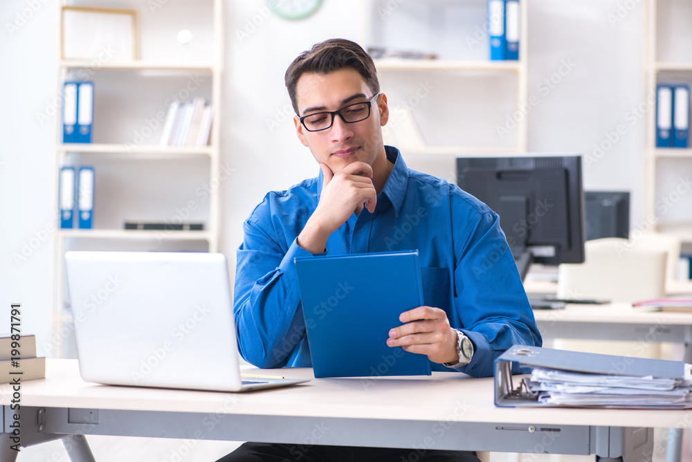 Handsome businessman employee sitting at his desk in office