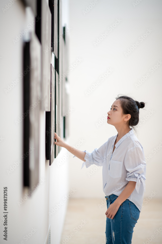 woman looking at the pictures on the wall woman looking at the pictures on the wall