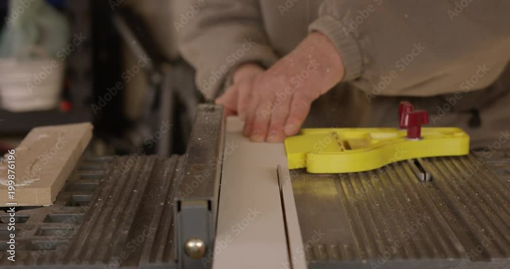 Man performs rip cut on table saw in workshop - slow motion head on shot Man performs rip cut on table saw in workshop - slow motion head on shot