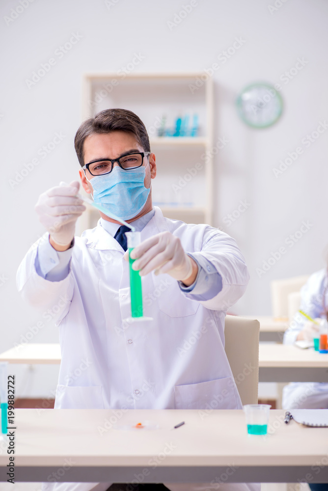 Man student working in chemical lab on experiment Man student working in chemical lab on experiment