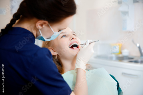 Dentist woman examining a patient's teeth in dentist.