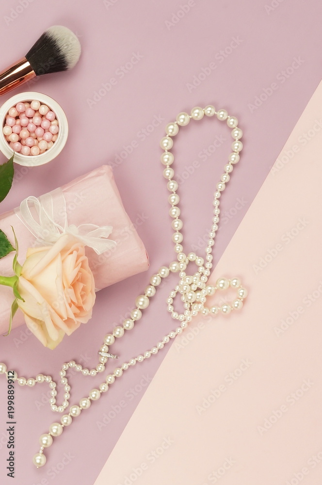 Fresh rose flowers, present box, cosmetics and pearl necklace on pale pink purple background. Top view.flat lay. copy space Fresh rose flowers, present box, cosmetics and pearl necklace on pale pink purple background. Top view.flat lay. copy space