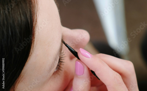Close-up of a beautiful woman paints her eyebrows. Top view.