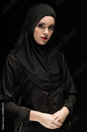 Bild auf Leinwand Beautiful young woman wearing black hijab as conservative fashion concept on bla
