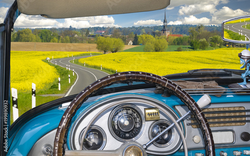 view from inside a retro cabriolet riding a country road