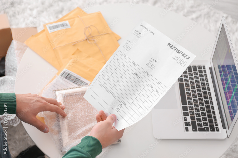 Naklejka premium Young man with purchase order sheet for parcel at home