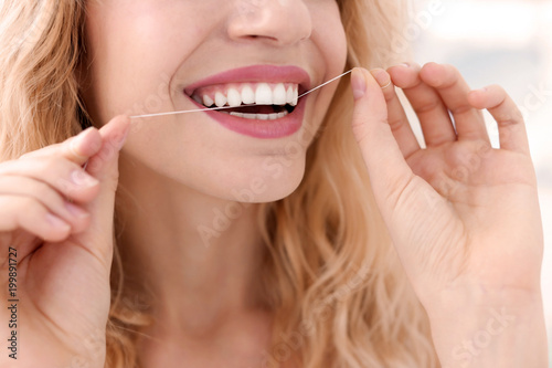 Young woman flossing her teeth  closeup