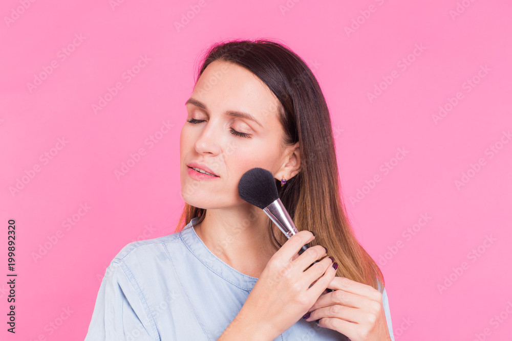 Beautiful young woman applying cosmetic powder on her face with tassel, skin care concept Beautiful young woman applying cosmetic powder on her face with tassel, skin care concept