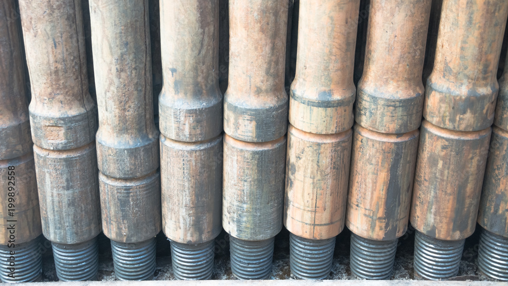Drill pipes are installed vertically in the drilling rig. The thread is coated with grease. Drill pipes are installed vertically in the drilling rig. The thread is coated with grease.
