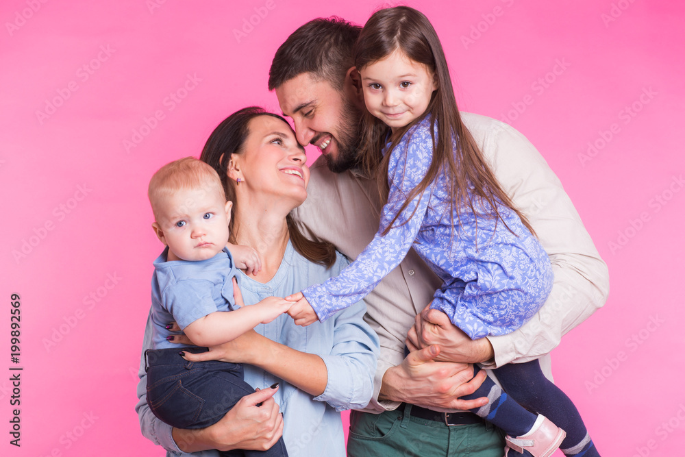 Happy mixed race family portrait smiling on pink background Happy mixed race family portrait smiling on pink background