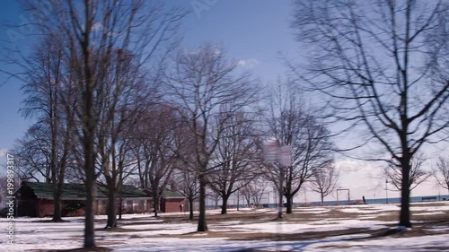 Wallpaper Mural looking rear,  left we see a sparse winter park with a lake in the background. stabilized driving plate shot. sunny winter. Torontodigital.ca
