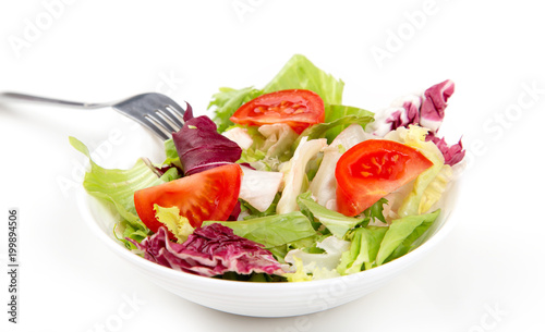 Salad mix of fresh green leaves frieze, radicchio, endive and tomato. Dietary vegetable menu.