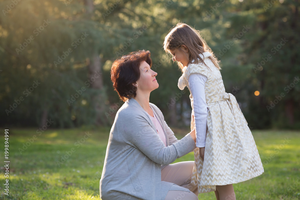 Happy mother and little daughter looking at each other, mother holding little girl, mother's day concept Happy mother and little daughter looking at each other, mother holding little girl, mother's day concept