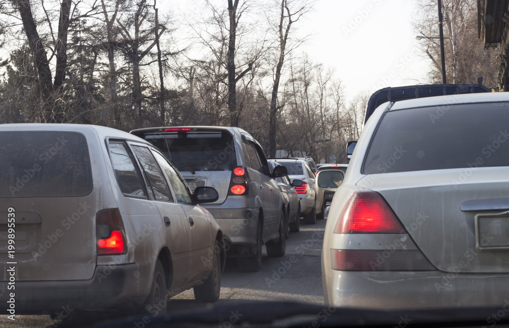 Dirty cars stand on the road in traffic jams