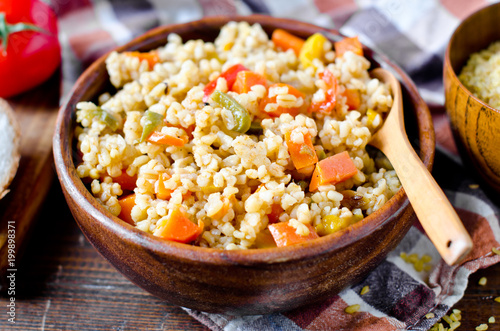 Porridge from bulgur with vegetables: carrots, bell peppers, onions, zucchini