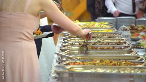 buffet table guests take food.
