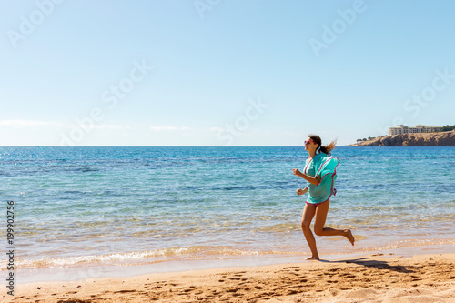 happy girl run along the sea coast