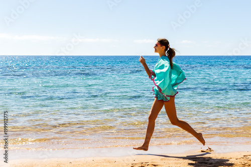 Running woman on the bech. Female runner jogging during outdoor workout on beach