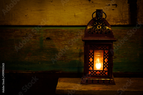 Retro style lantern with a candle at night photo