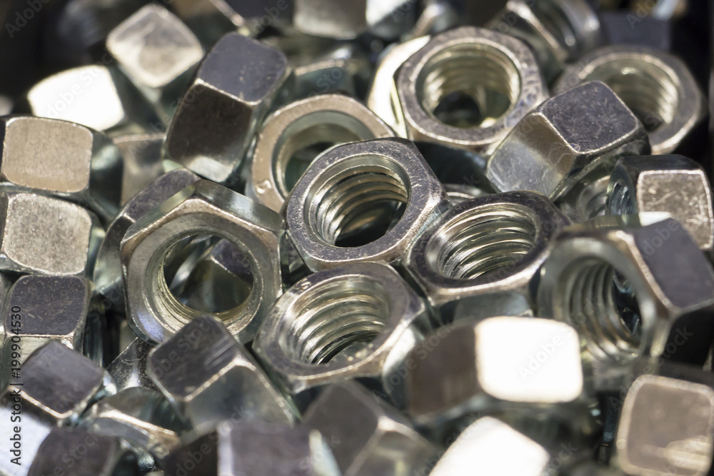 shiny metal nuts lie in the pile. Background. Close up. shiny metal nuts lie in the pile. Background. Close up.