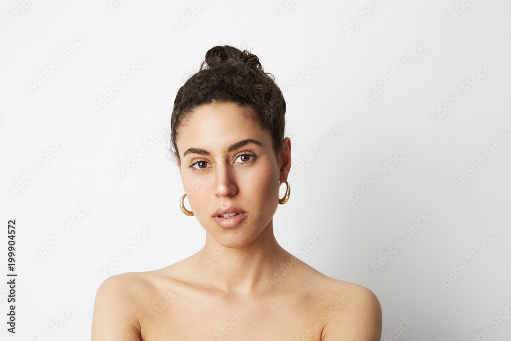 Close up portrait of a beautiful young woman with nude mack-up. White background.